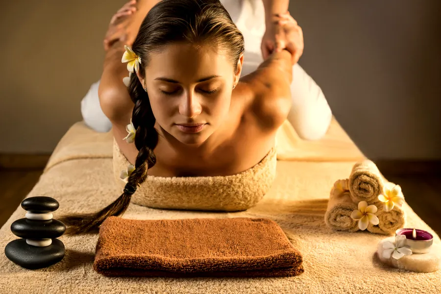 Traditionelle Thai-Massage: eine Frau wird auf der Matte gedehnt
